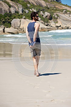 Man walking alone on secluded beach with diary