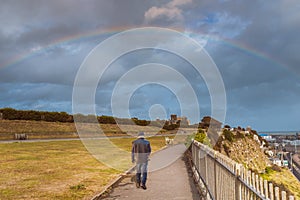 A man walking along the cliff top promenade of the Royal Esplanade in Ramsgate, Kent, UK.