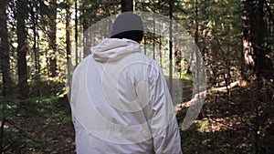 Man walking along path through forest. Footage. Rear view of man all alone. Concept of active recreation in nature