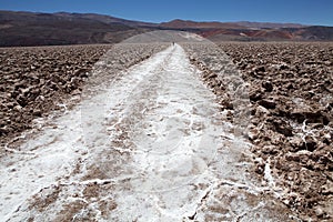 Man is walking along the trail at the salt pan at the Salar of Antofalla at the Puna de Atacama, Argentina
