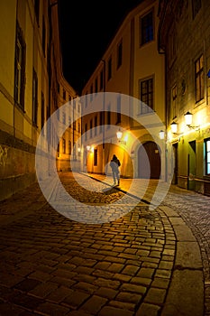 Man walking around the street of the old town at night in Pragu
