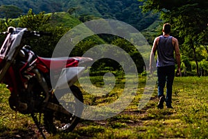 Man walking away from dirt bike in Guatemalan mountains