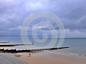Man walking on beach, Sheringham, North Norfolk coast, East Anglia