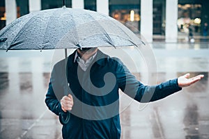 Man walking in the city with umbrella on rainy day