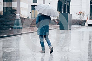 Man walking in the city with umbrella on rainy day