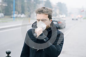 Man walking in city wearing mask against smog air pollution