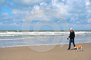 Man walking the dog at the beach