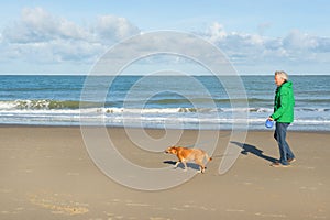 Man walking with dog at the beach