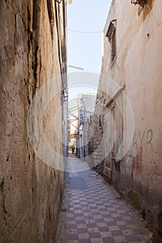 A man walking down an alley in Tripoli, Libya