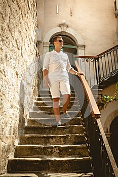 Man walking down the old stone staircase at sunny day