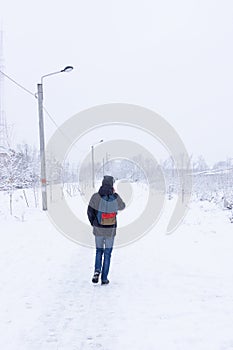 Man walking down the snowed city alley