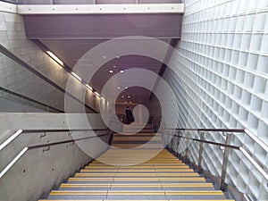 A man walking downstair, stairway to subway, glass block wall,