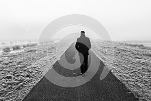 Man walking on an empty desolate raod