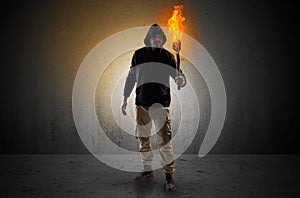 Man walking in an empty space with burning flambeau