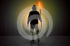 Man walking in an empty space with burning flambeau