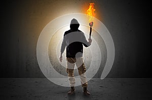 Man walking in an empty space with burning flambeau