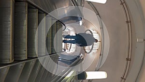 Man walking on escalator in illuminated building