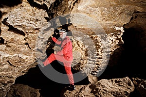 Man walking and exploring dark cave with light headlamp underground. Mysterious deep dark, explorer discovering mystery moody