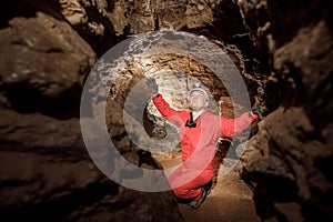 Man walking and exploring dark cave with light headlamp underground. Mysterious deep dark, explorer discovering mystery moody