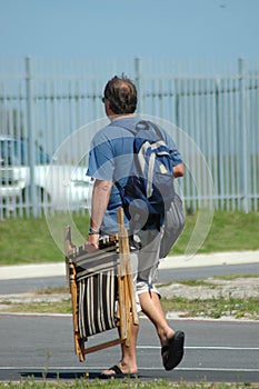 Man walking with folding chair
