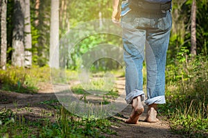 Man walking on footpath forest. Close-up of bare feet soiled with ground. healthy lifestyle.