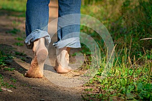 Man walking on footpath forest. Close-up of bare feet soiled with ground. healthy lifestyle.