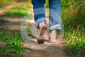 Man walking on footpath forest. Close-up of bare feet soiled with ground. healthy lifestyle.