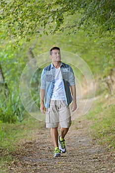 Man walking on forest path in autumn