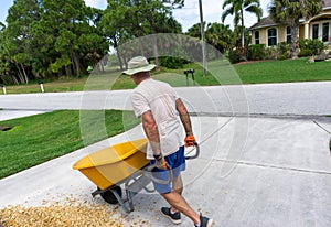 Man walking full wheelbarrow with rocks