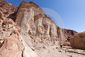 Man walking hiking deep desert canyon.