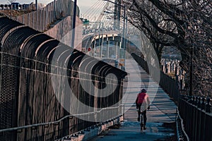 a man is walking his bicycle down a pathway in the winter