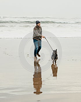 Man walking his dog on the beach with waves ocean background