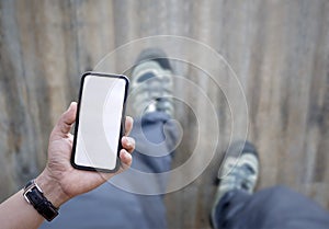 Man on walking and holding smartphone with white blank screen