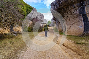 Man walking among huge eroded rocks in the Enchanted City of Cuenca