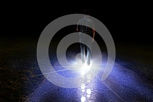 Man walking with light foot prints in darkness