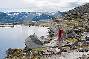 Man walking on a mountain trail in Norway. Path to Trolltunga or