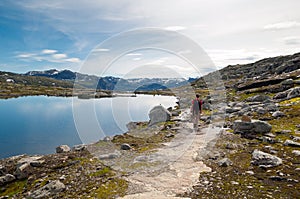 Man walking on a mountain trail in Norway. Path to Trolltunga or