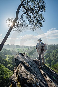 A man walking on a mountain trail overlooking the valley