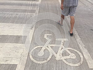 The man walking near bicycle road sign