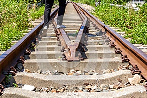 A man walking on old rusty railway tracks outdoors