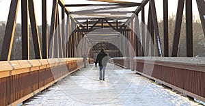 Man walking over footbridge