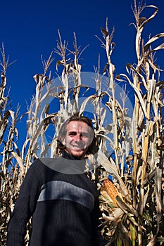 Man walking past corn field