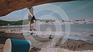 Man walking on pollution beach. Problem of environmental pollution with plastic. Slow motion