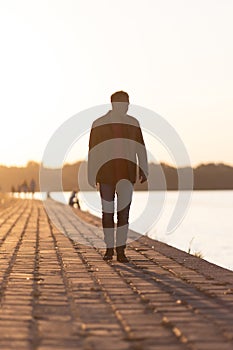man walking on river edge