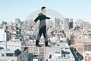 Man is walking on a rope at city background