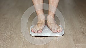 Man walking on scales measure weight. male wal checking BMI weight loss. human barefoot measuring body fat overweight