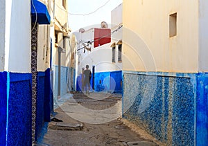 Man walking in the small streets in blue and white in the kasbah of the old city Rabat in Marocco