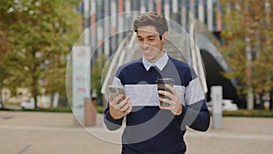 Man Walking, SMS Texting Using App on Smartphone, Holding Coffee Using Mobilephone,