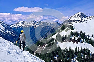 Man Walking on Snow Covered Mountain Top with Beautiful Views.