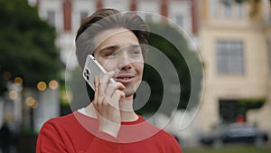 Man Walking, Talking on Mobile Phone With Friends on the Street. Smiling Guy Making a Phone Call Outdoors. Cheerful Male